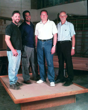 four men standing on our floating platform bed